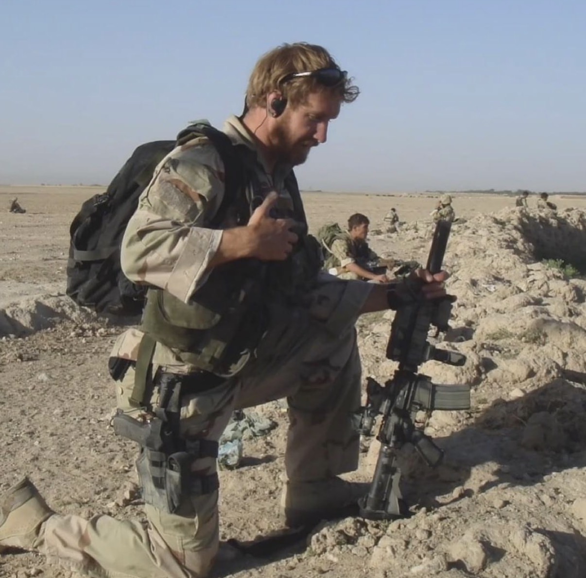 Operator kneeling in the field during a training exercise